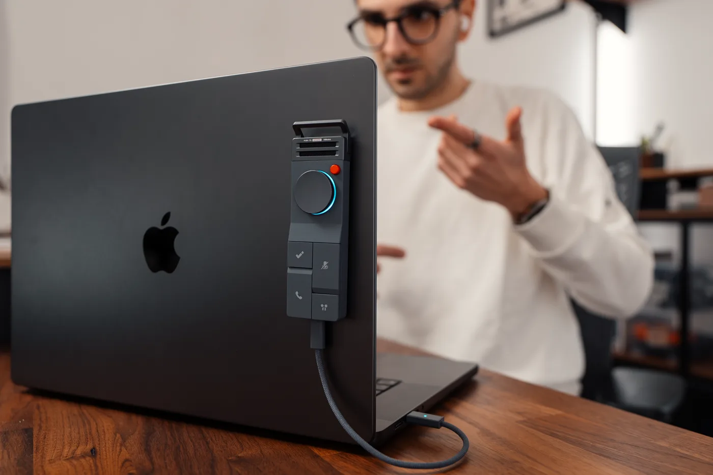 A person speaking beside a HiDock P1 mounted on a MacBook